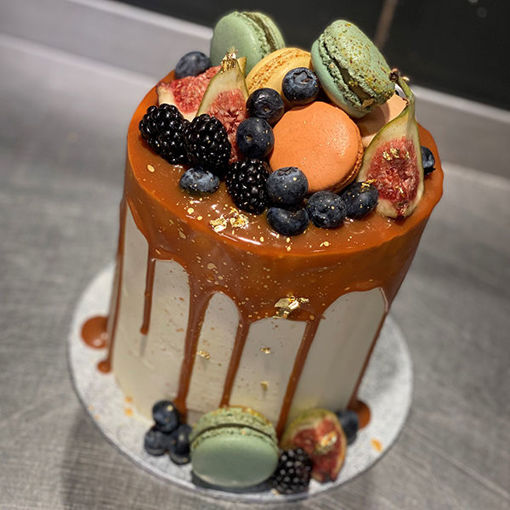 Afbeelding van Driptaart caramel afgewerkt met macarons en fruit.